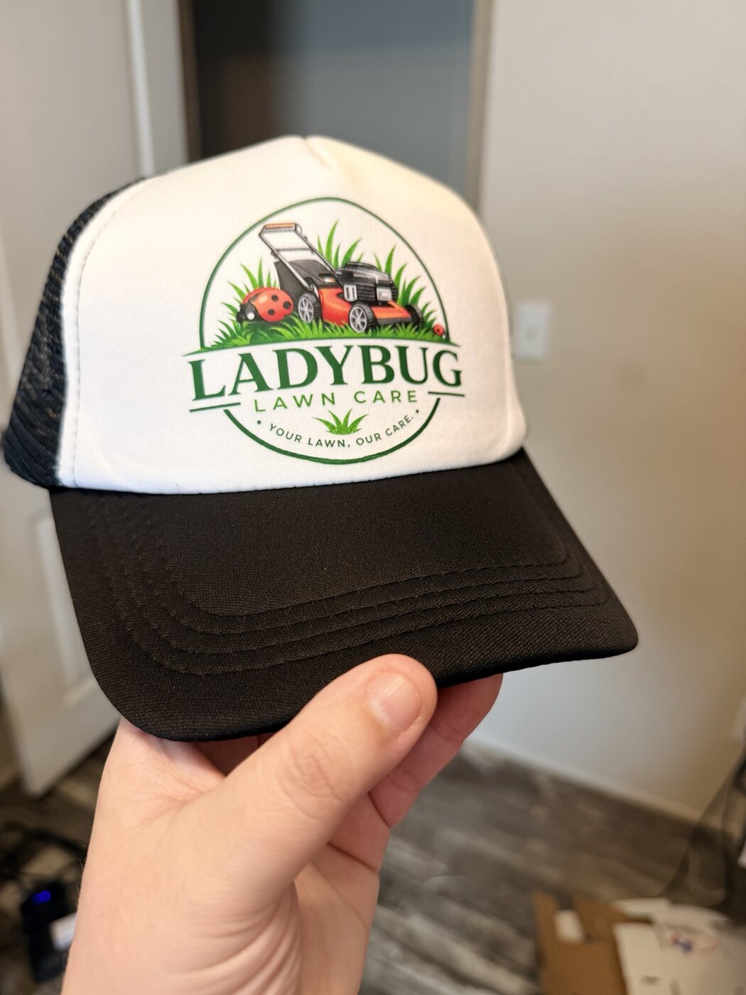 Custom black and white trucker hat for Ladybug Lawn Care