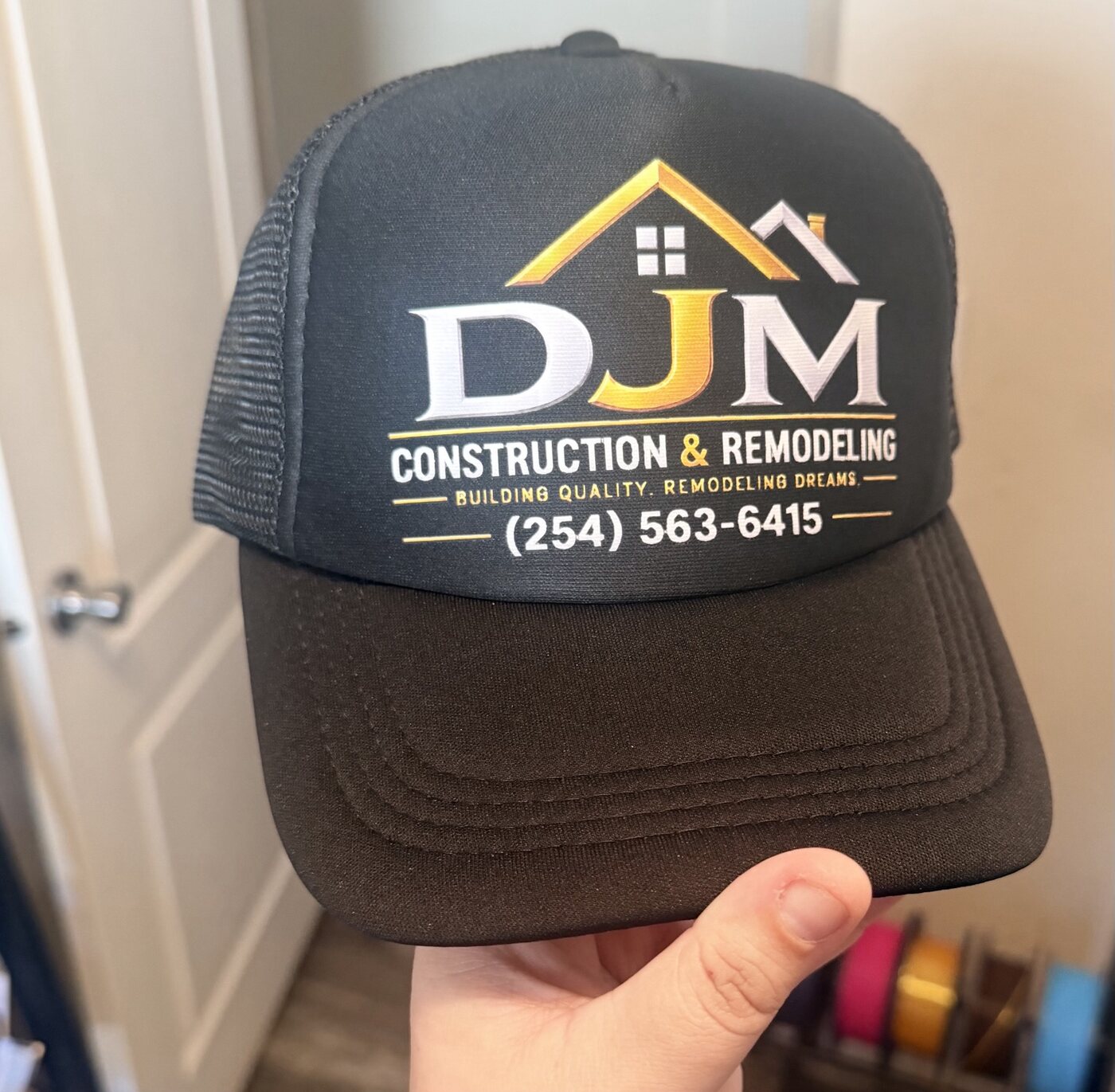 Custom black trucker hat for DJM Construction and Remodeling